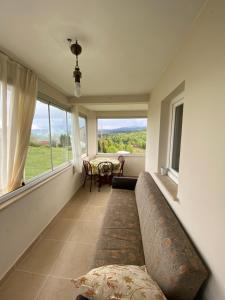 a living room with a couch and a large window at Hıdırnebimountainhome in Akcaabat