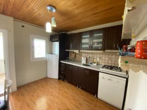 a kitchen with brown cabinets and a white refrigerator at Hıdırnebimountainhome in Akcaabat