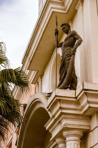 uma estátua de um homem ao lado de um edifício em Envy Hotel em Durrës