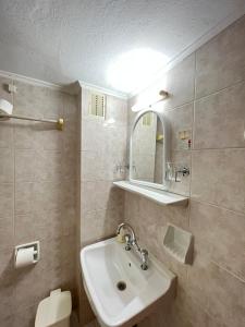 y baño con lavabo y espejo. en Asterias Hotel - Seafront en Parikia