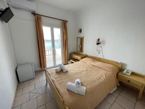 1 dormitorio con 1 cama con 2 toallas en Asterias Hotel - Seafront en Parikia