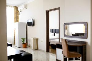 a room with a bed and a tv and a desk at Apartments 37B in Batumi