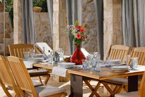 a long wooden table with a vase of flowers on it at Villa Vito in Hvar