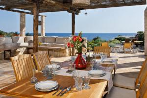 a wooden table with plates and a vase with flowers at Villa Vito in Hvar