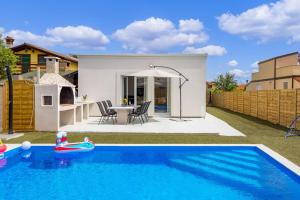 a swimming pool in the backyard of a house at Cosy holiday home Infinity with pool and BBQ in Loborika