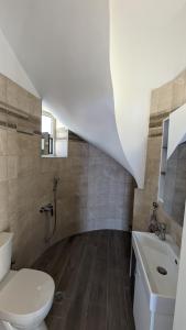 a bathroom with a white toilet and a sink at Rapunzel's Tower Mani in Neokhórion