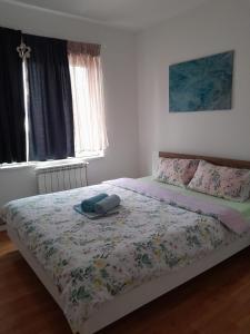 ein Schlafzimmer mit einem Bett mit einer Bettdecke darauf in der Unterkunft Apartment Ken in Surčin