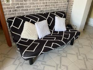 a black and white couch with two pillows on it at Alba Marina in Fezzano