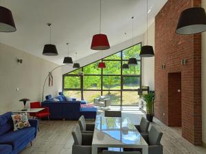 a living room with blue couches and a brick wall at Instytut Wypoczynku in Sulęczyno