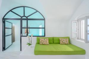 a green couch in a room with a window at Nano Oia Canaves in Oia