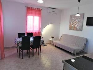 a living room with a bed and a table and chairs at Villa Stella in Rogoznica