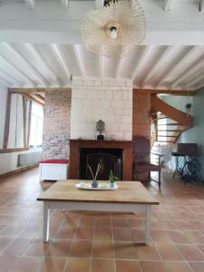 een woonkamer met een open haard en een tafel bij Happiness la maison du bien-être (100 m2) 