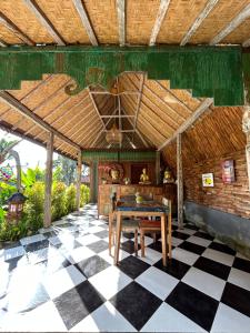 um pátio com uma mesa e um piso em xadrez em Puri Sundaram Villa em Ubud