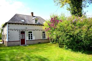 een wit huis met een rode deur in een tuin bij Happiness la maison du bien-être (100 m2) 