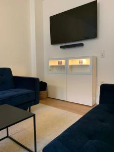 a living room with two blue couches and a flat screen tv at Redlinburg II in Quedlinburg