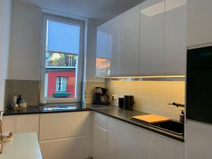 a kitchen with white cabinets and a window at Redlinburg II in Quedlinburg