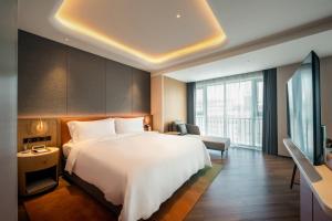 Habitación de hotel con cama y TV en Jingju Hotel Shenzhen en Shenzhen