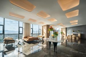 een woonkamer met een tafel en stoelen bij Jingju Hotel Shenzhen in Shenzhen