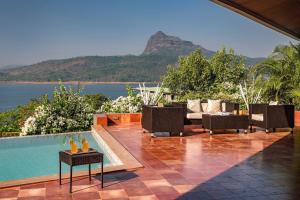 a resort with a pool and a view of the ocean at SaffronStays Shambhala Lakeside-Infinity Pool Villa in Pawna in Malavli