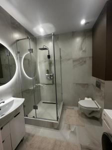 Уютная квартира в центре города في أورالسك: حمام مع دش ومرحاض ومغسلة