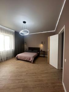 1 dormitorio con cama y lámpara en Уютная квартира в центре города, en Uralsk