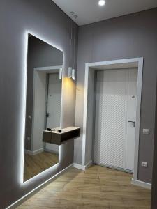 W łazience znajduje się umywalka i lustro. w obiekcie Уютная квартира в центре города w mieście Uralsk