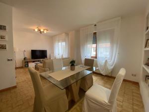 comedor y sala de estar con mesa y sillas en House Cooper - 2 Min Dal Mare, en Marina di Carrara