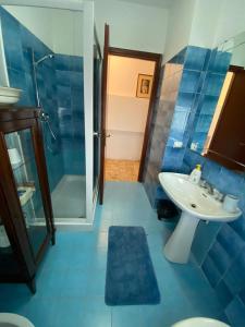y baño azul con lavabo y ducha. en House Cooper - 2 Min Dal Mare, en Marina di Carrara