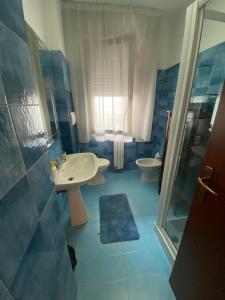 Baño azul con 2 lavabos y ducha en House Cooper - 2 Min Dal Mare, en Marina di Carrara