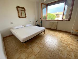 1 dormitorio con cama y ventana grande en House Cooper - 2 Min Dal Mare, en Marina di Carrara