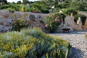 a garden with flowers and a stone wall at Villa Vito in Hvar