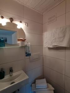 een badkamer met een wastafel, een toilet en een spiegel bij Steakhouse Fieg in Fuschl am See
