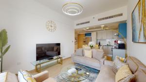 un soggiorno con divano e tavolo di Primestay - 3BR in Wasl Gate, close to Metro Station a Dubai