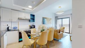 a kitchen and living room with a table and chairs at Primestay - 3BR in Wasl Gate, close to Metro Station in Dubai