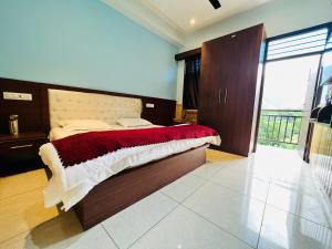 a bedroom with a large bed with a red and white blanket at Hotel Anjum Regency in Bajaura