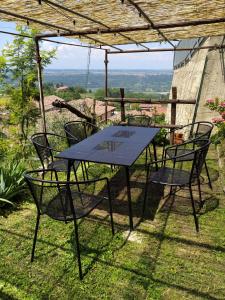 a table and chairs sitting under a pergola at Casa Mantel Holiday Home Panoramic view in Langhe in Novello