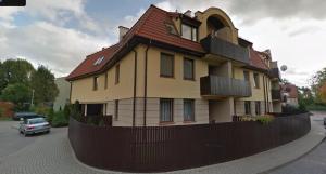 a house with a red roof on a street at APARTAMENT 202 in Giżycko