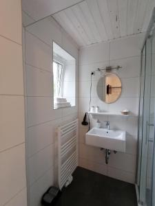 a white bathroom with a sink and a mirror at Steakhouse Fieg in Fuschl am See