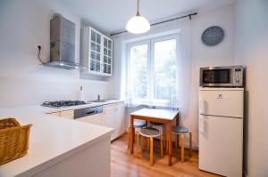 a kitchen with a white refrigerator and a table with stools at CITYSTAY Sopot Nadmorski Apartament 5 min od plaży in Sopot