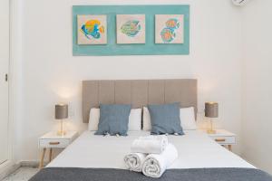 Un dormitorio con una gran cama blanca con dos lámparas. en MONKÓ BONAIRE, en Torremolinos