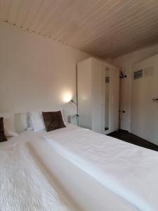 a bedroom with a large white bed with a cabinet at Steakhouse Fieg in Fuschl am See