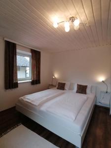 a large white bed in a room with a window at Steakhouse Fieg in Fuschl am See