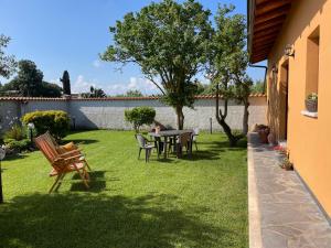 a patio with a table and chairs in a yard at La Casetta in San Nicolò dʼArcidano