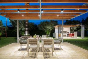 a patio with a table and chairs under a pergola at Gala's Elegant Home Villa in Zakynthos