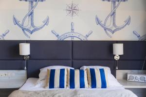 a bed with blue and white pillows in a bedroom at Villa Herkules - Adults Only in Świnoujście