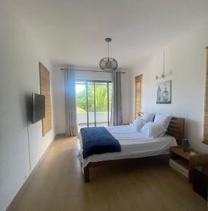 ein Schlafzimmer mit einem großen Bett und einem Fenster in der Unterkunft Villa Coco in Trou aux Biches