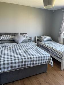 two beds in a room with white walls at Armada Cottages Bundoran in Bundoran