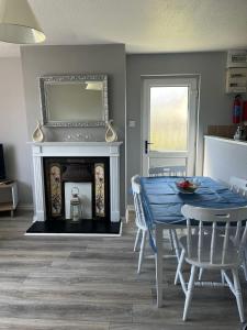 a dining room with a blue table and a fireplace at Armada Cottages Bundoran in Bundoran