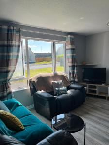 uma sala de estar com um sofá e uma televisão em Armada Cottages Bundoran em Bundoran