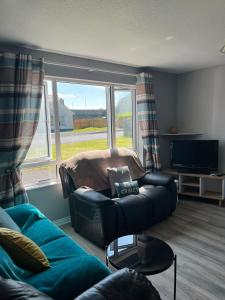a living room with a couch and a television at Armada Cottages Bundoran in Bundoran